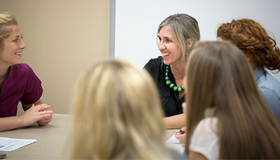 Group of people talking together at a conference room table.